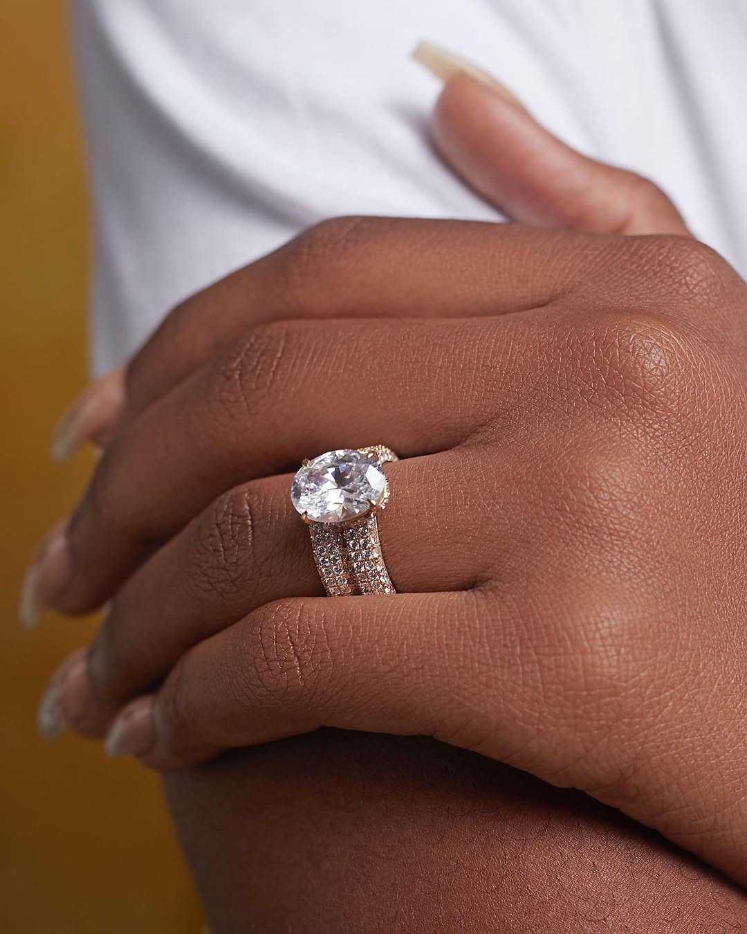 Crystal Oval Cut Moissanite bridal set in 18K gold on hand with pavé band