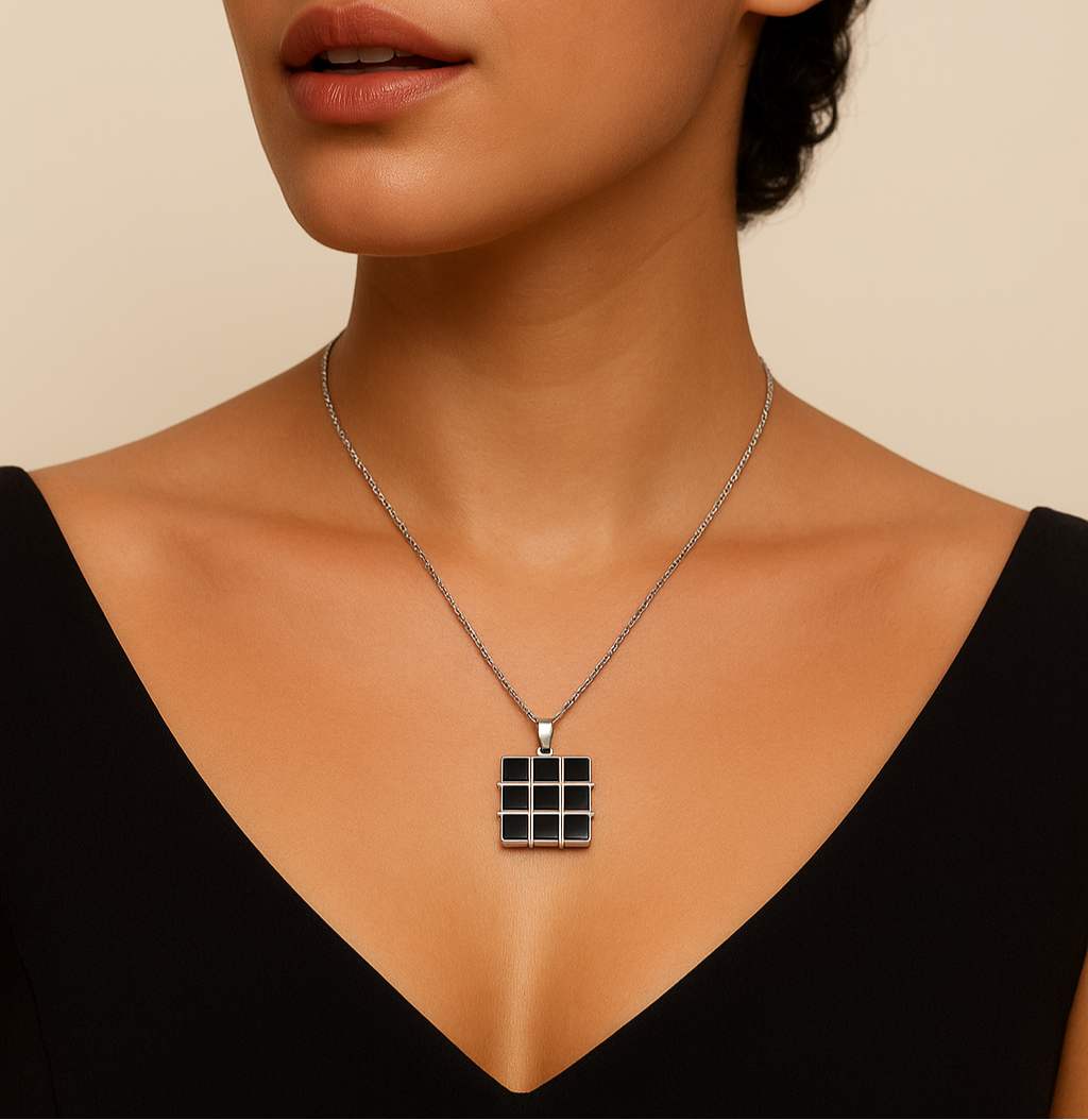 Woman wearing a necklace with a geometric pendant against a beige background