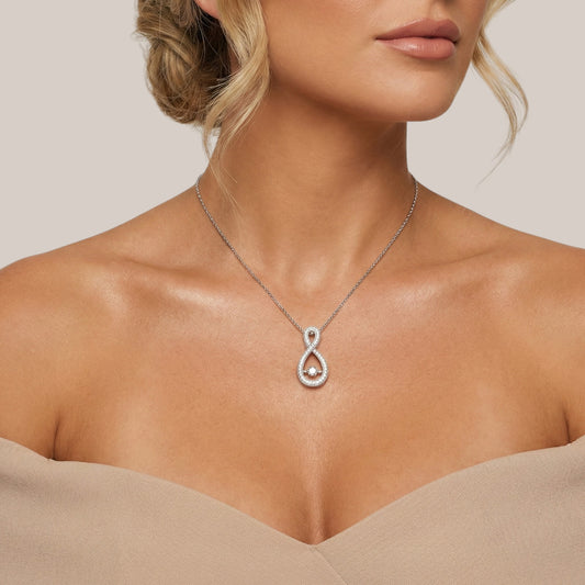 Silver necklace with a pendant worn by a model against a neutral background