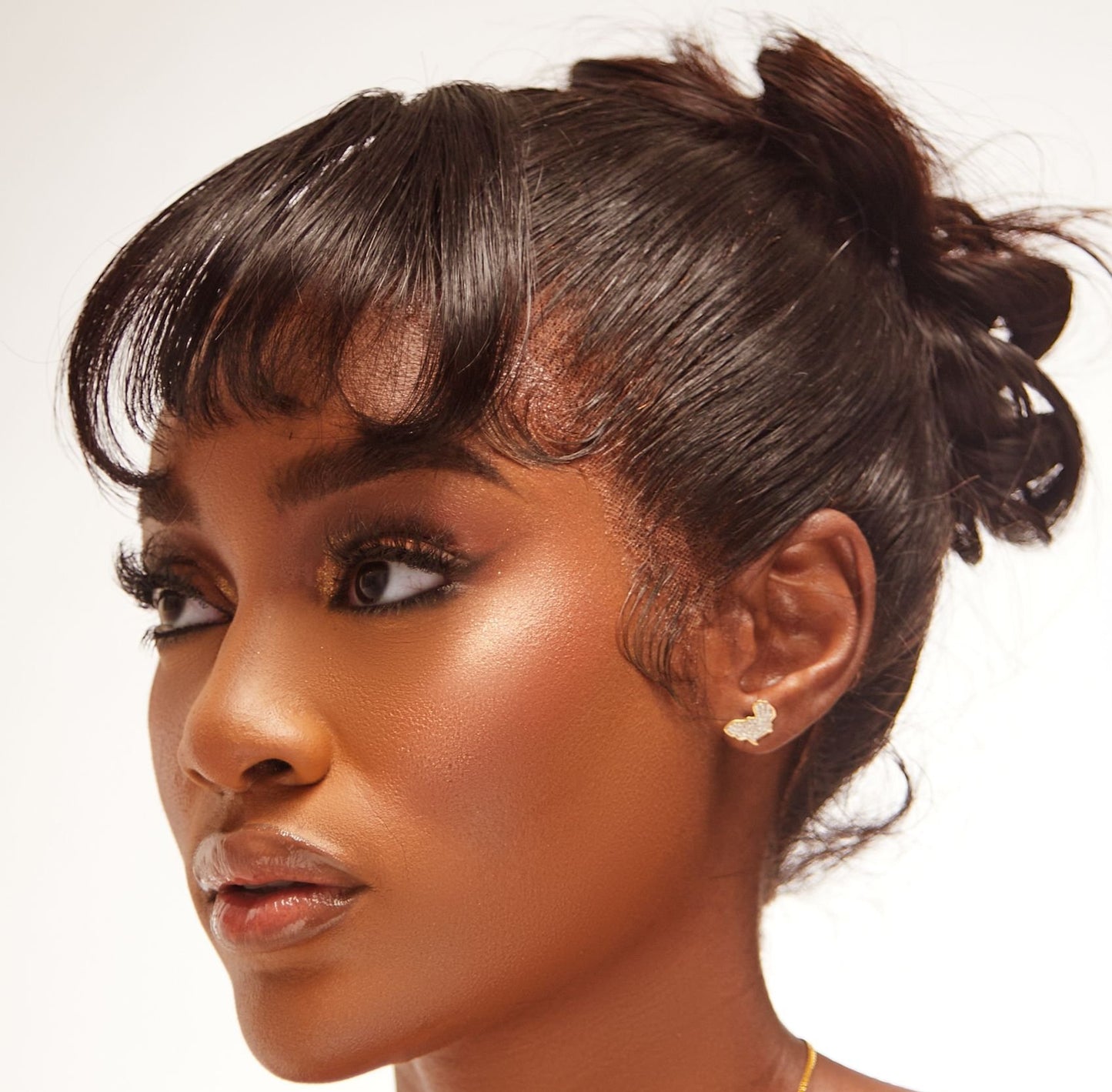 A woman showcasing a diamond stud earring in 18K gold.
