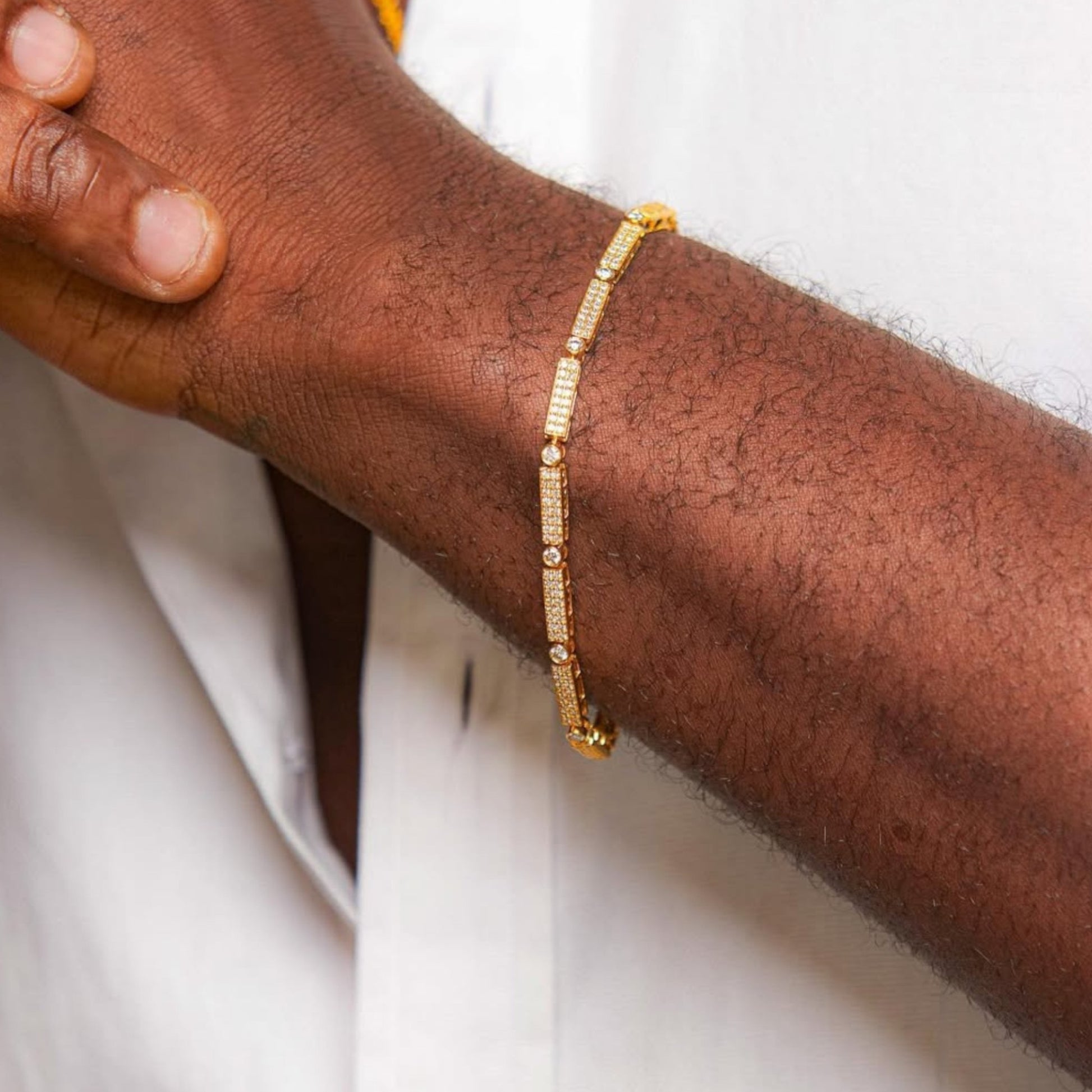 Gold bracelet on a person's wrist with a blurred background
