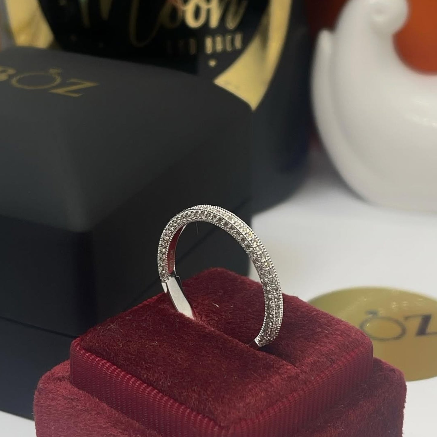 Silver ring on a red cushion with a blurred background