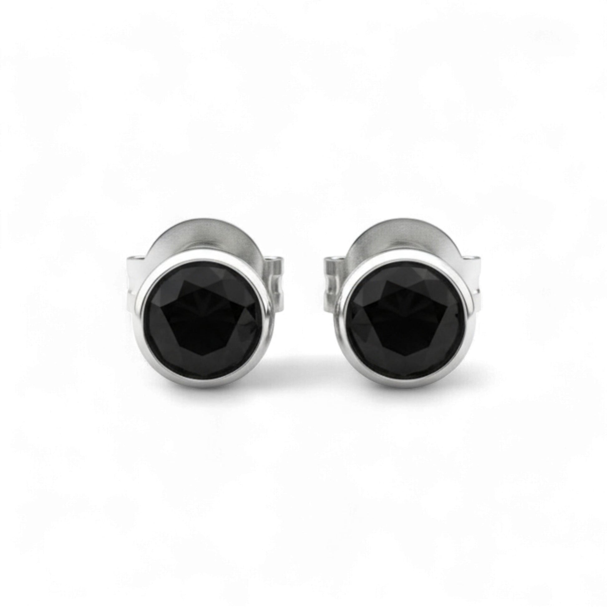 Pair of silver stud earrings with black gemstones on a white background