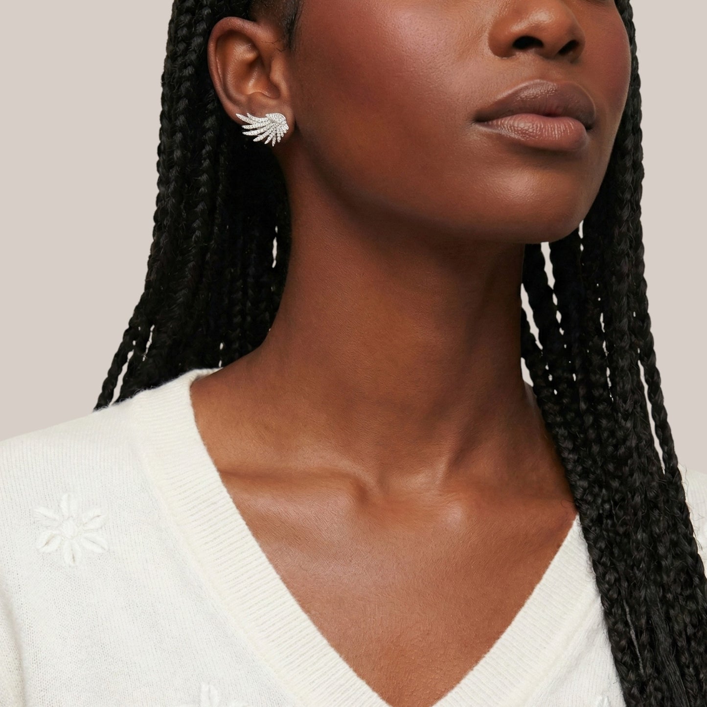 Woman wearing a white sweater with a neutral background