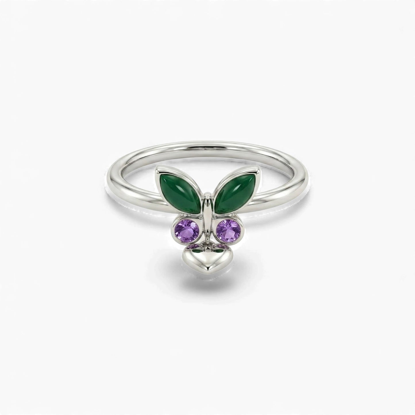 Silver ring with green butterfly wings and purple gemstones on a white background