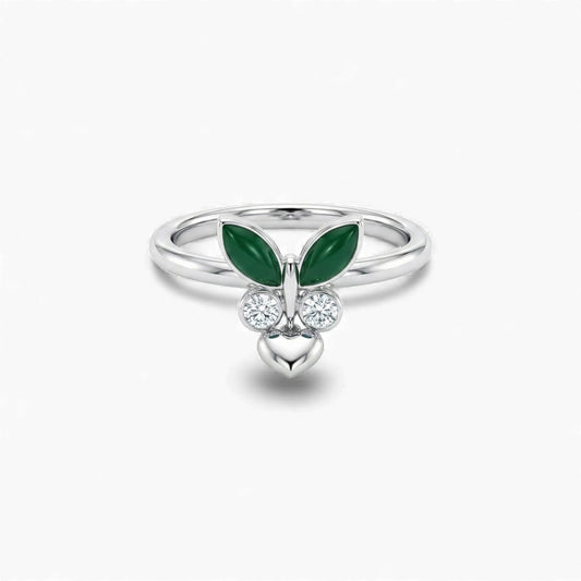 Silver ring with green gemstones and heart design on a white background