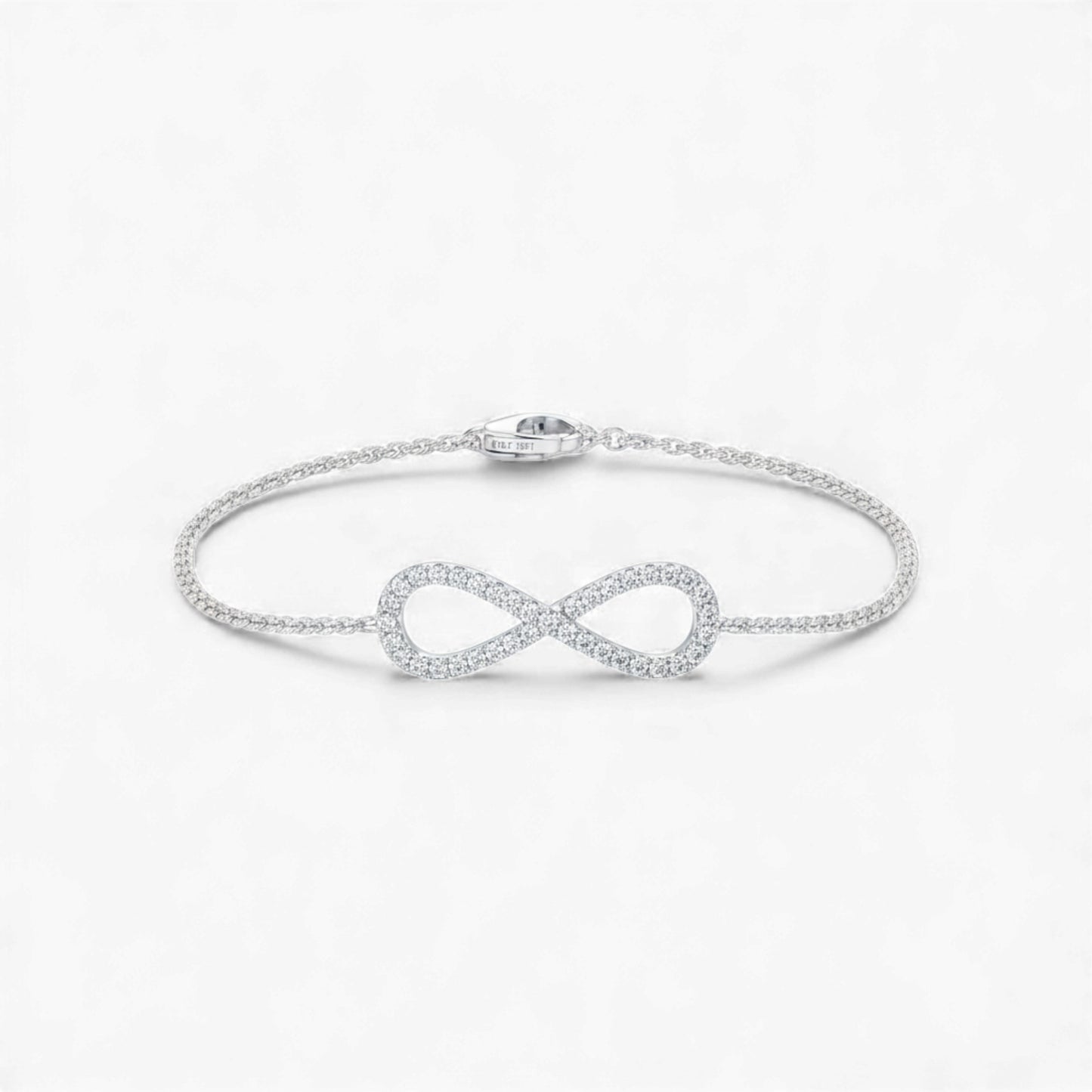 Silver infinity bracelet on a light gray background