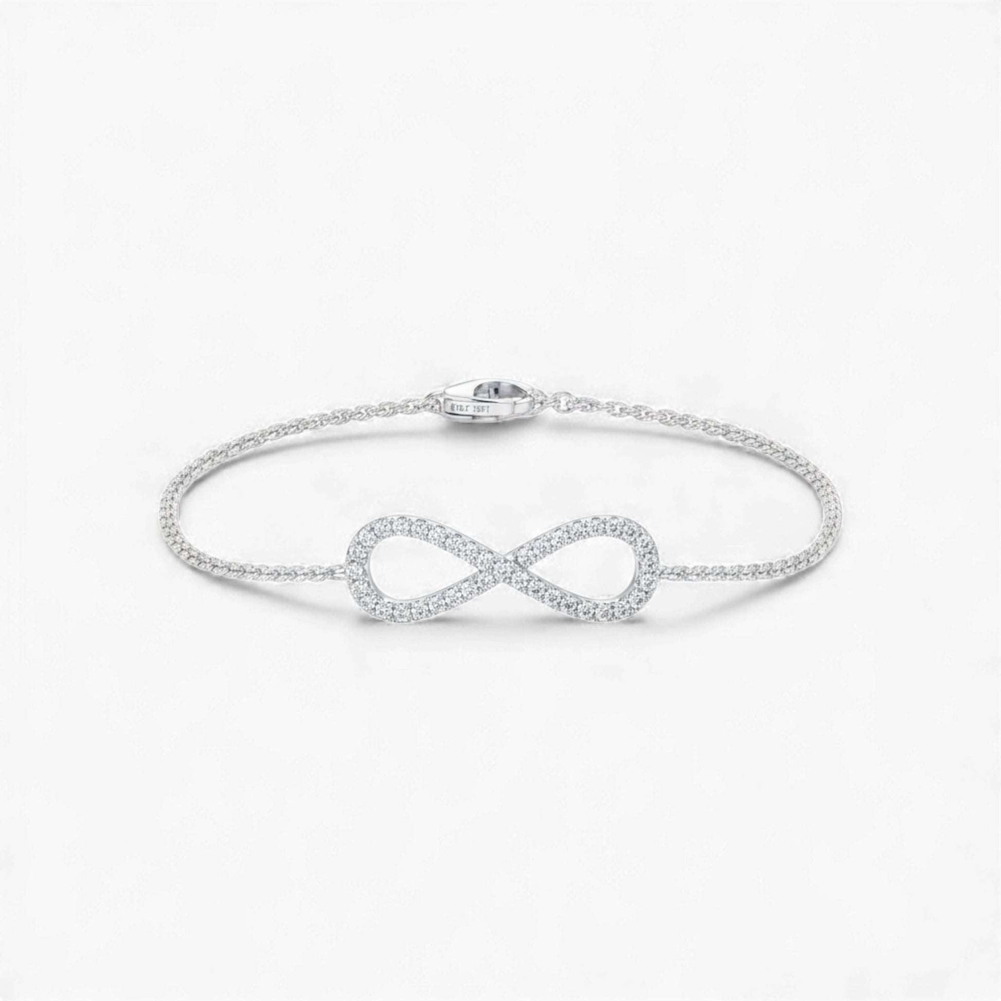 Silver infinity bracelet on a light gray background