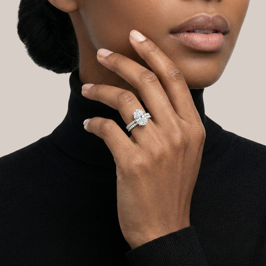 Close-up of a hand wearing a diamond ring with a neutral background