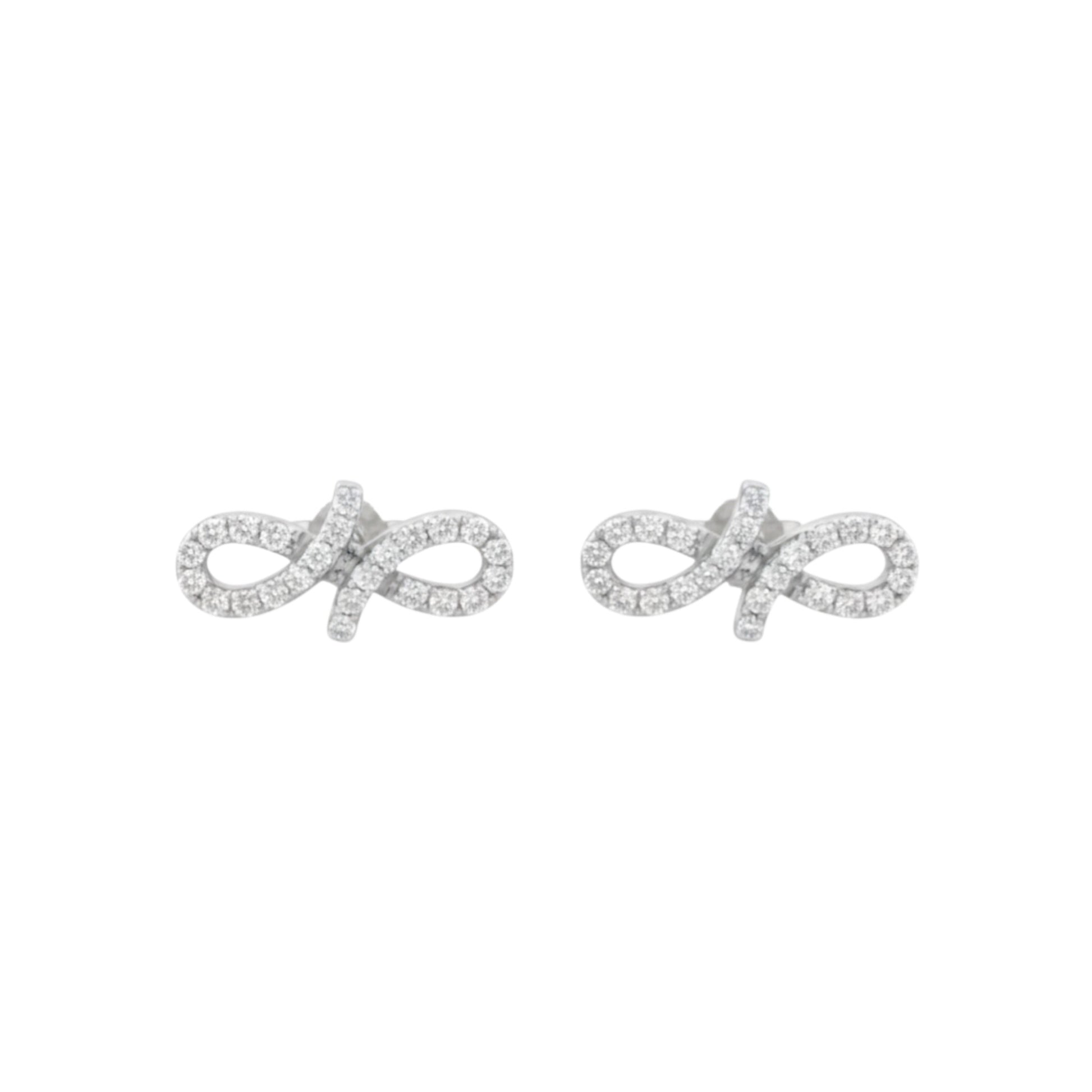 Pair of silver infinity symbol earrings on a white background