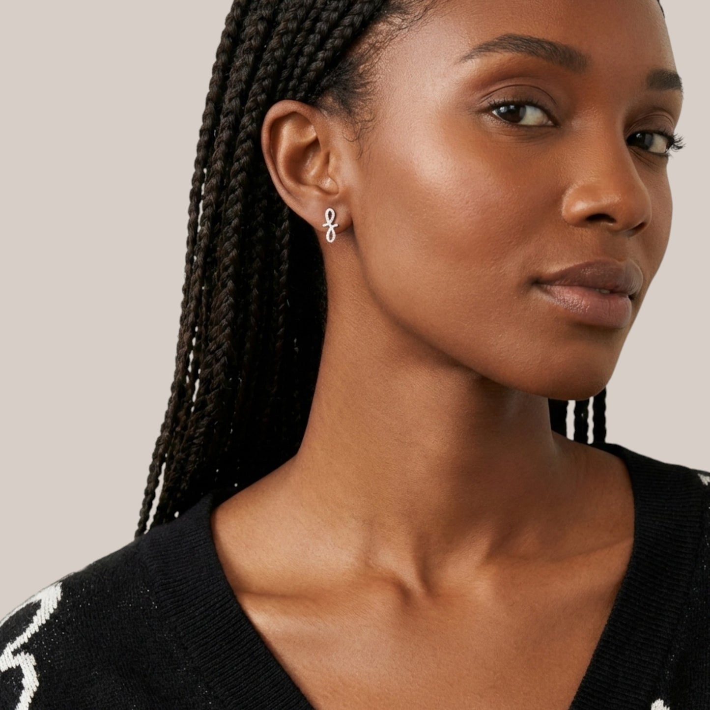 Woman wearing a black top with a white pattern, looking to the side.