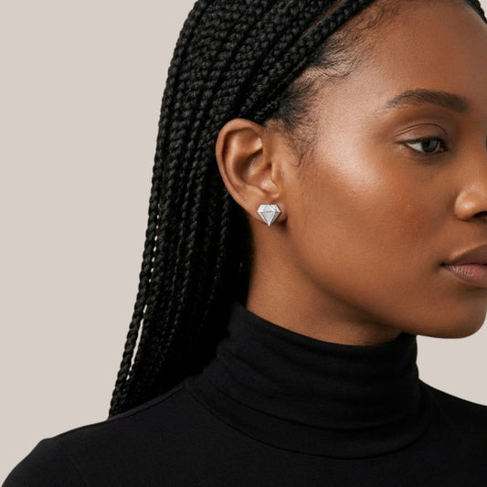 Woman wearing diamond earrings with a neutral background