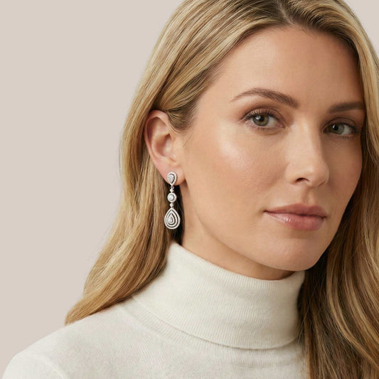 Woman wearing a pair of earrings with a neutral background