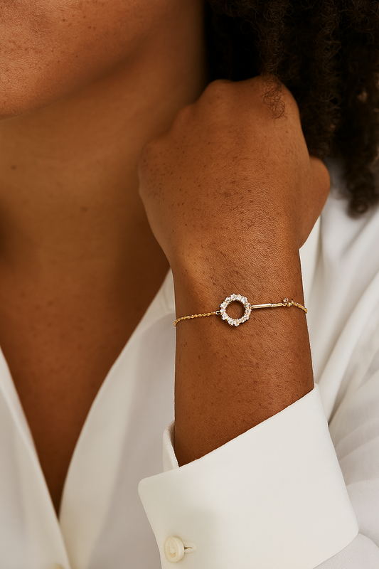 Close-up of a person wearing a gold bracelet with a circular design.