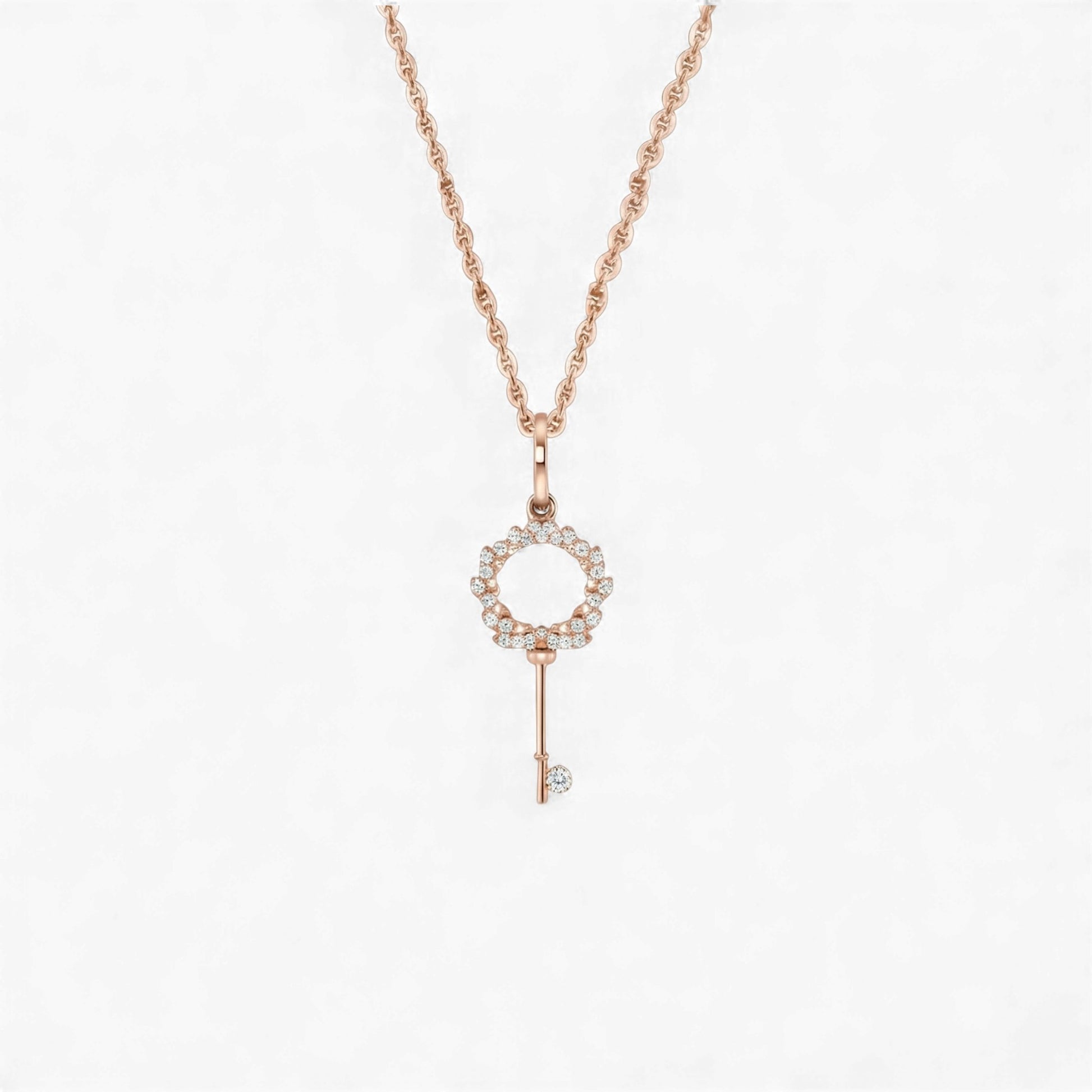 Rose gold key-shaped pendant necklace on a white background
