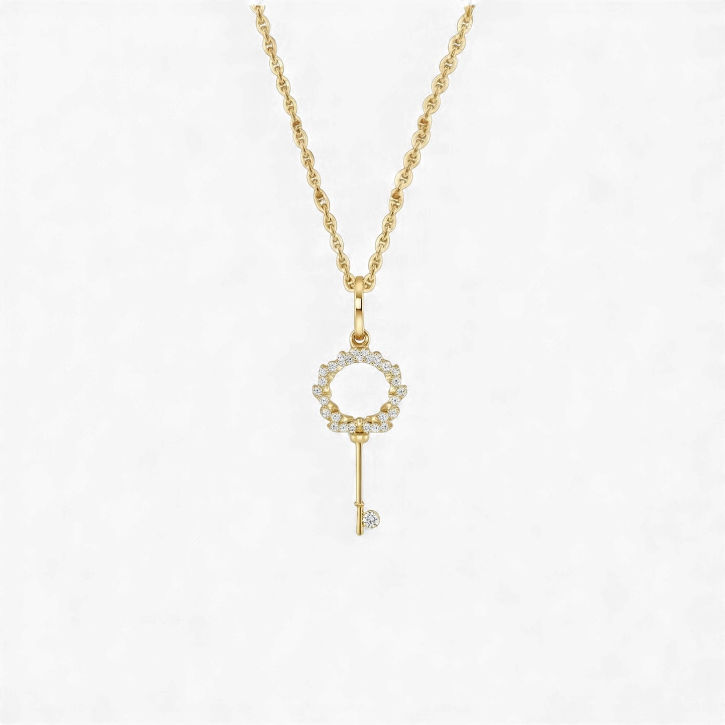 Gold key-shaped pendant necklace on a white background