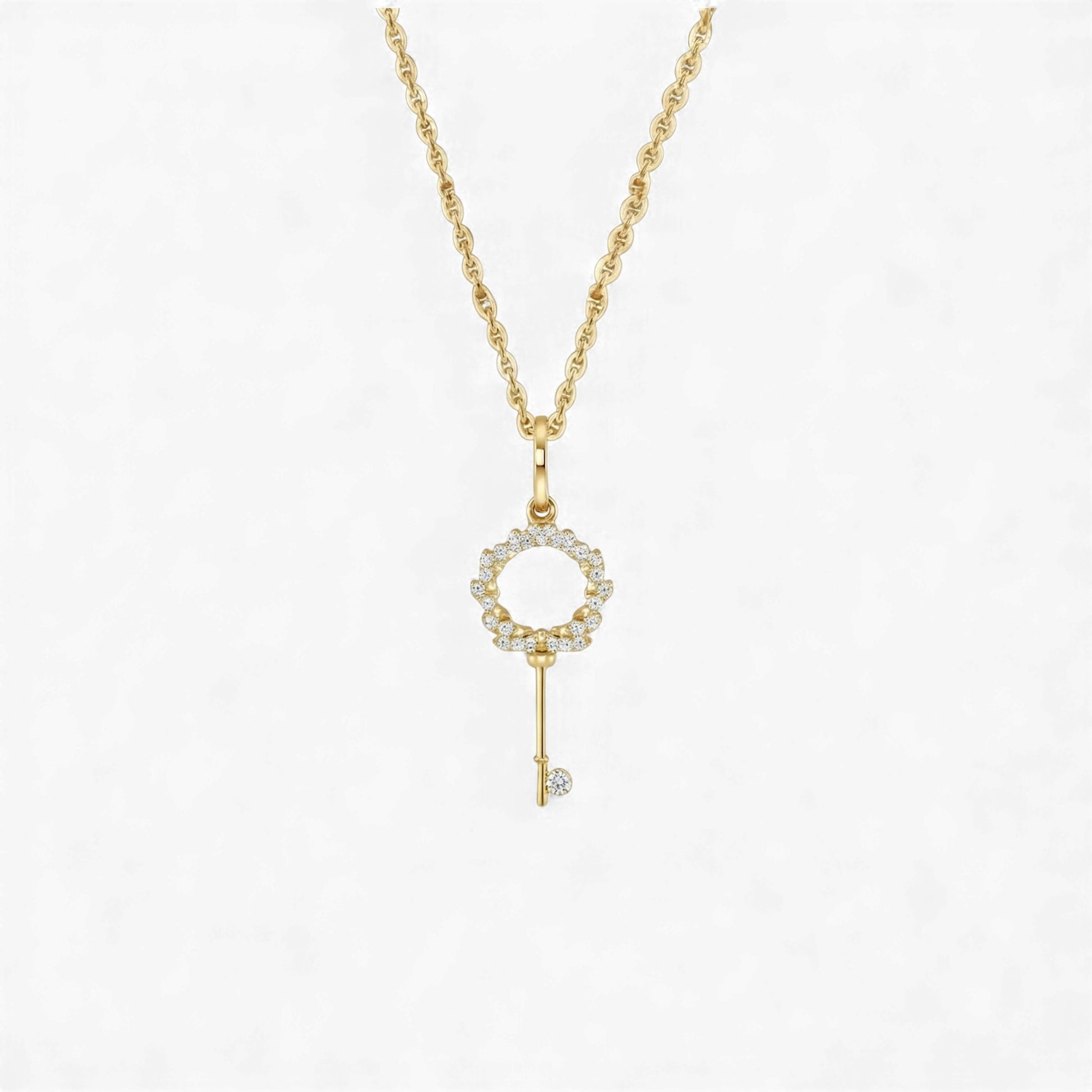 Gold key-shaped pendant necklace on a white background
