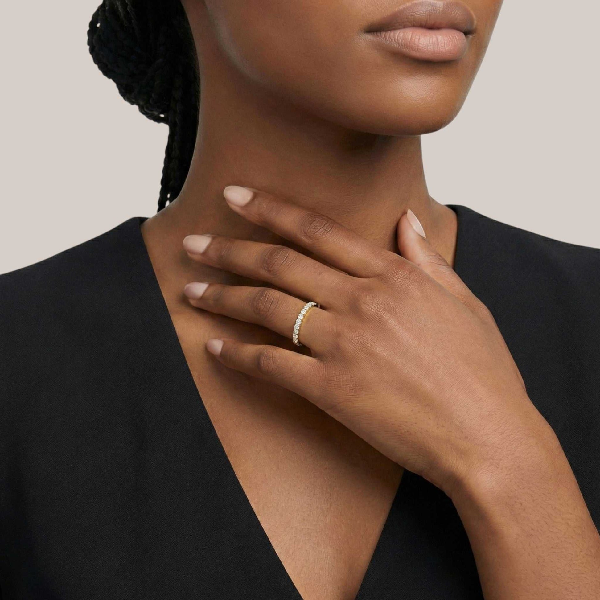 Woman wearing a gold ring on her hand with a neutral background