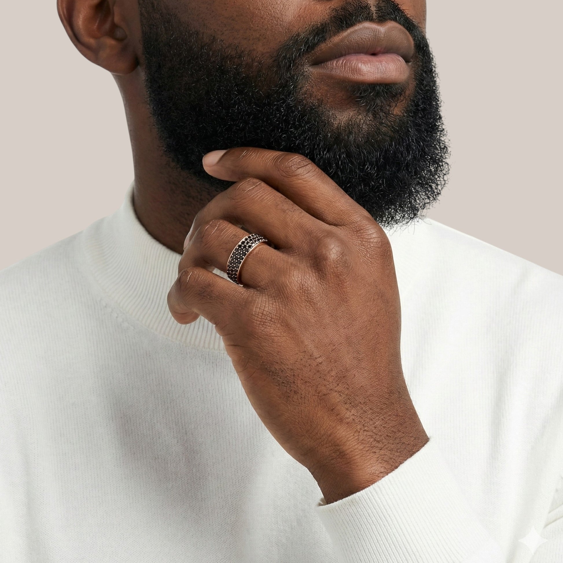 Man wearing a silver ring on his finger with a neutral background