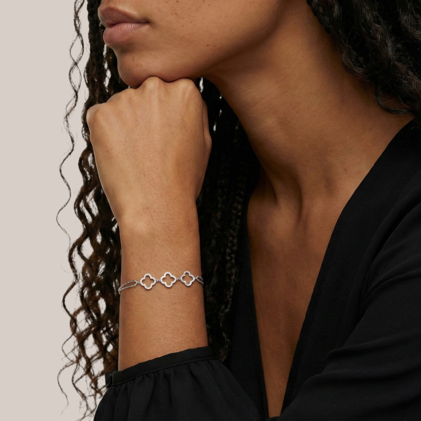 Woman wearing a silver bracelet on a neutral background