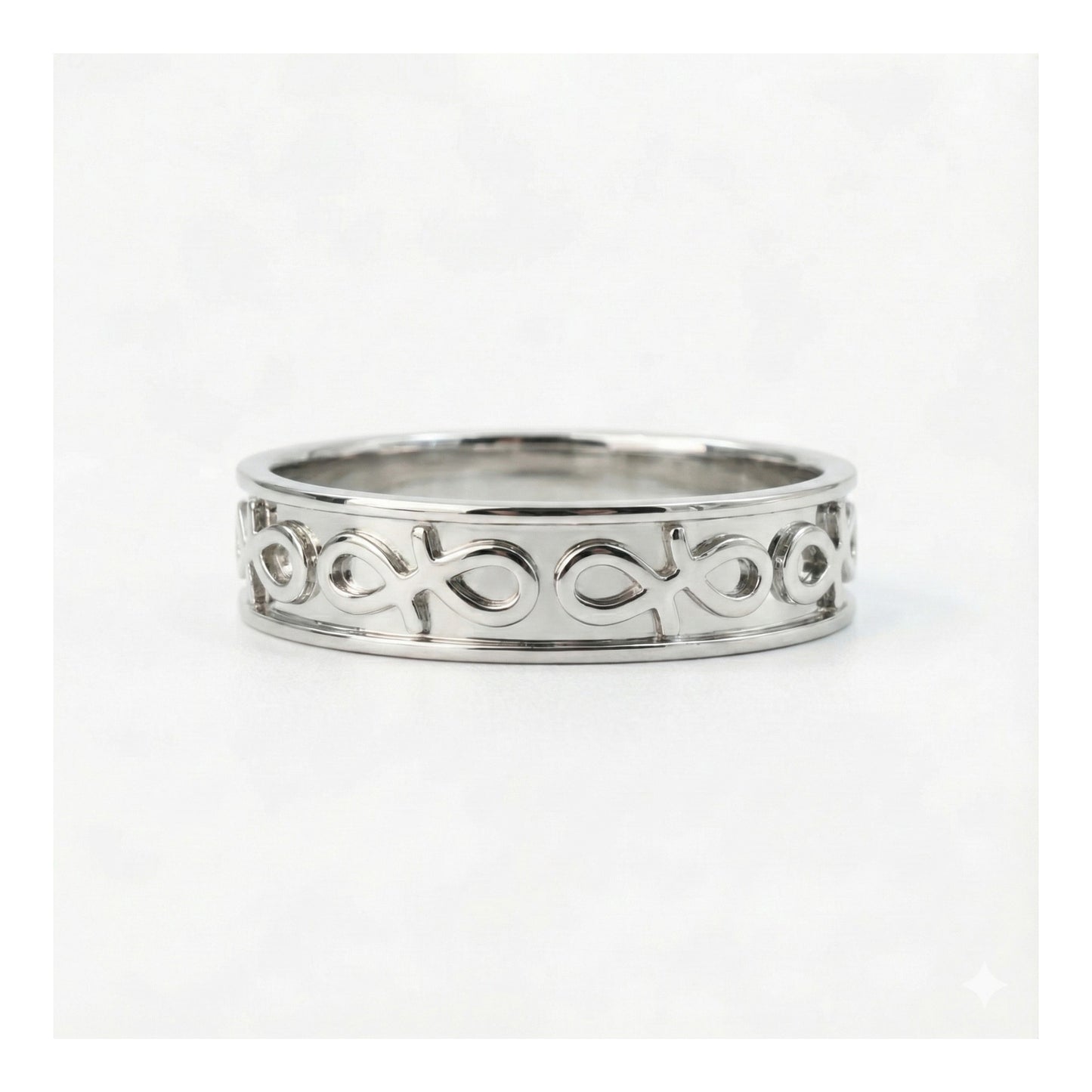 Silver ring with intricate design on a white background