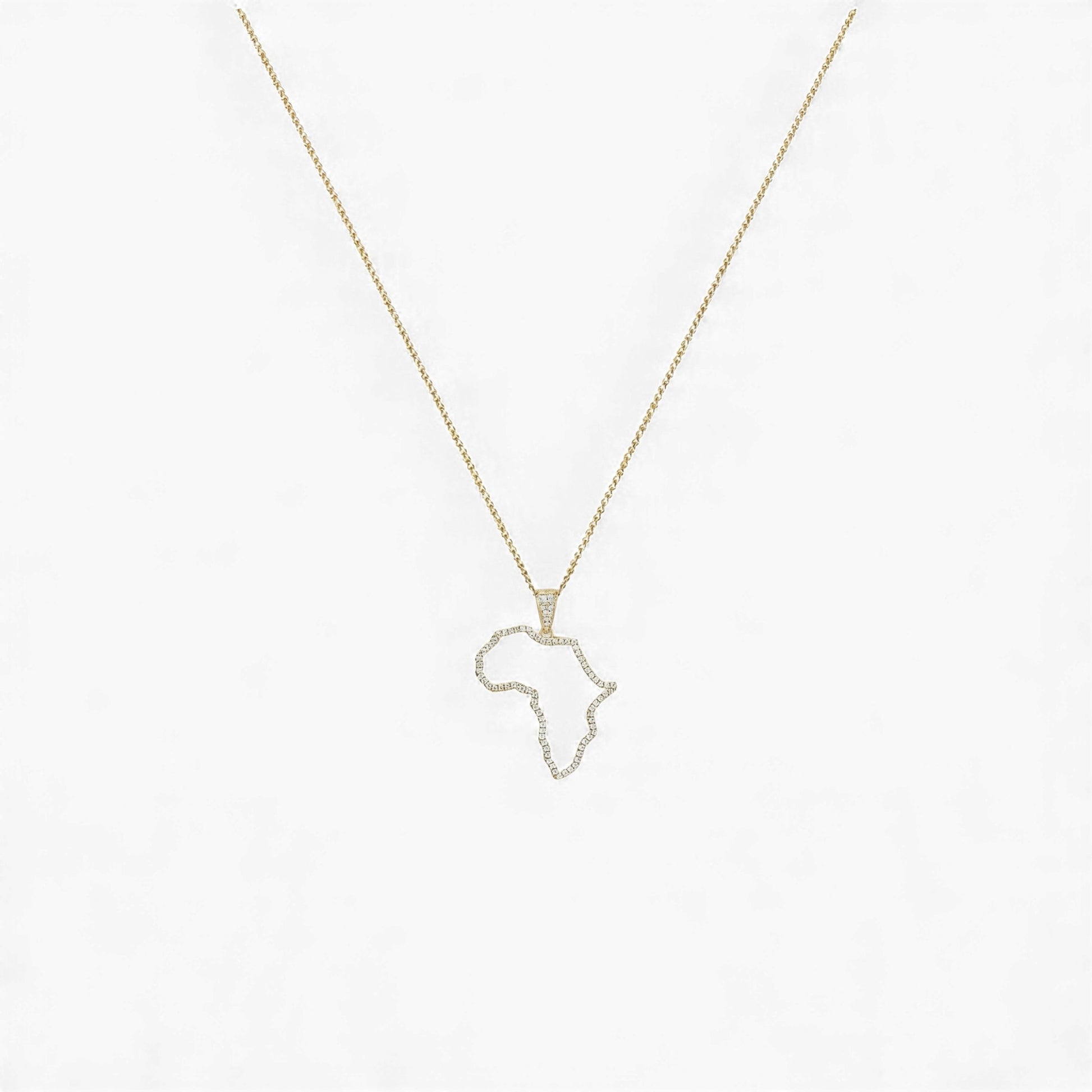 Gold necklace with a pendant shaped like the African continent on a light gray background