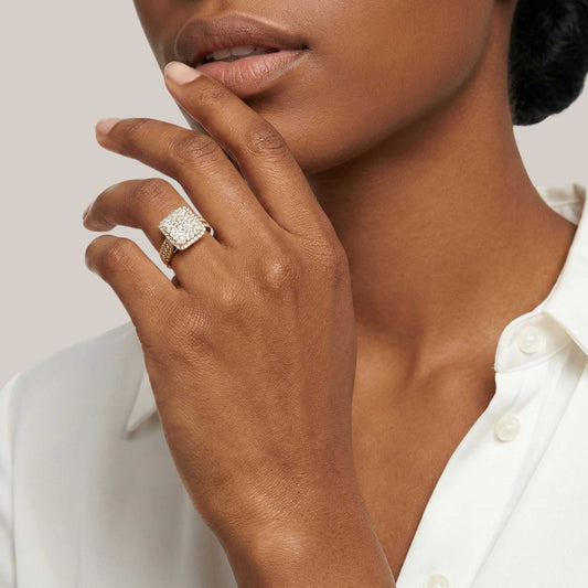 Close-up of a woman's hand wearing a diamond ring with a neutral background