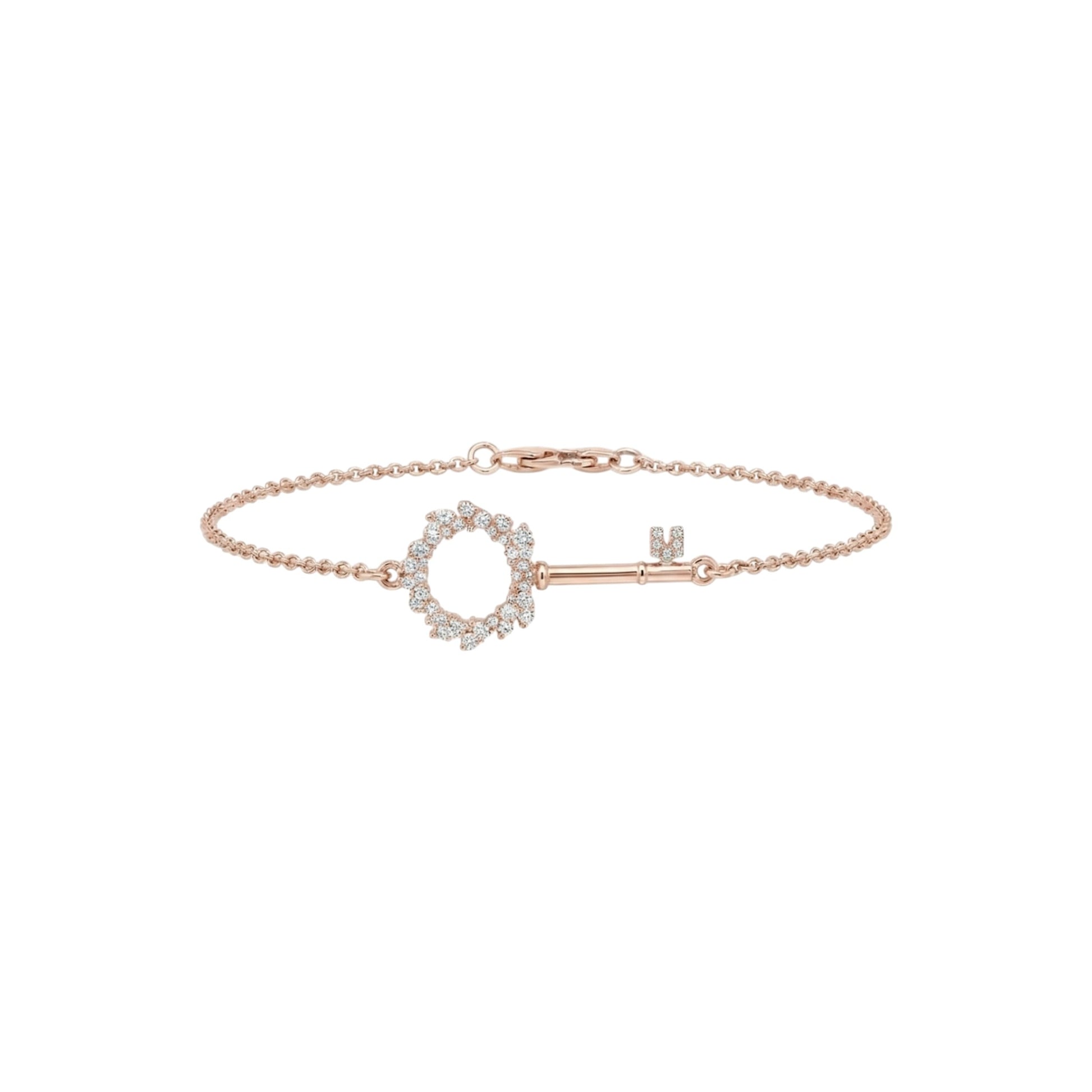 Rose gold bracelet with a key-shaped clasp on a white background