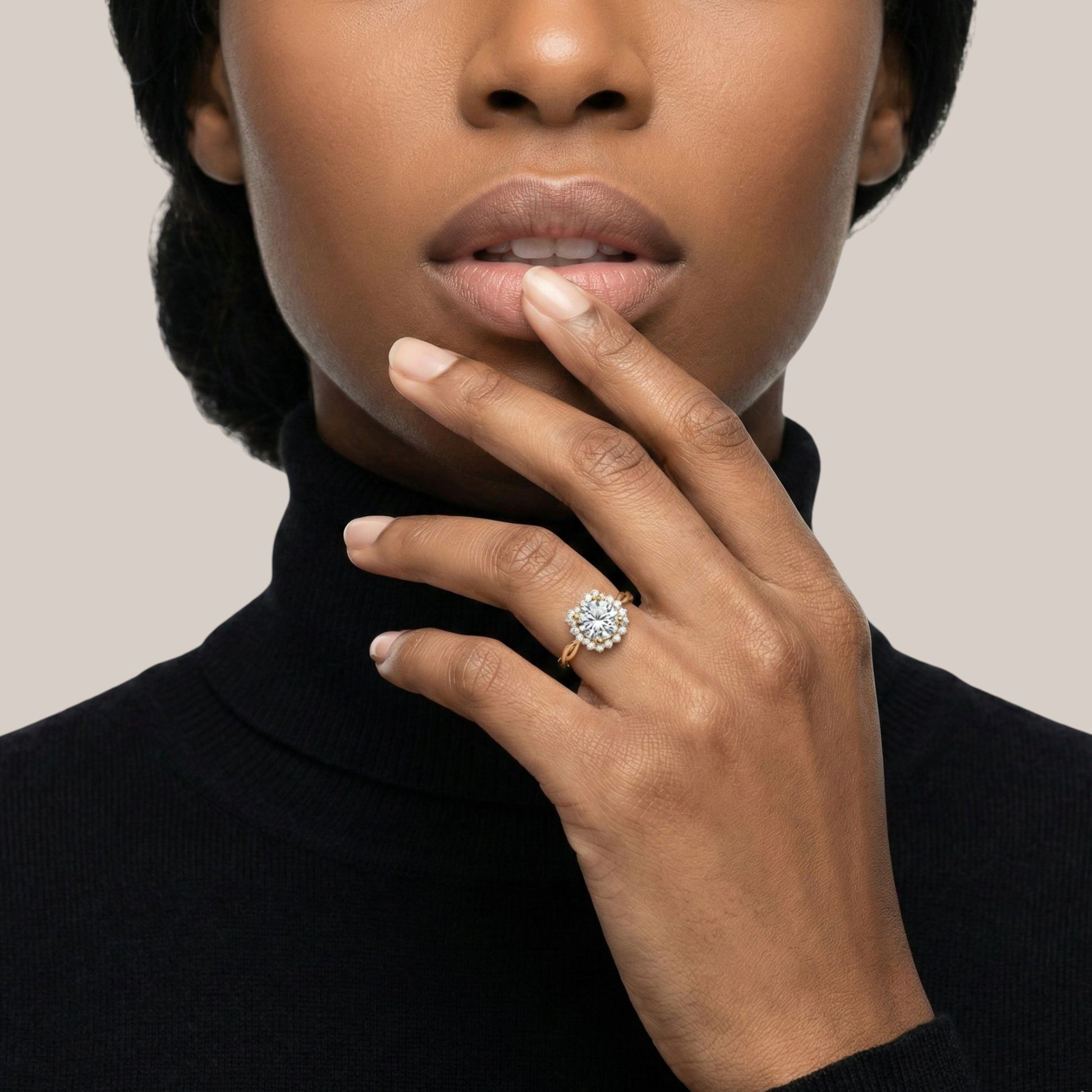 Woman wearing a diamond ring on her finger against a neutral background