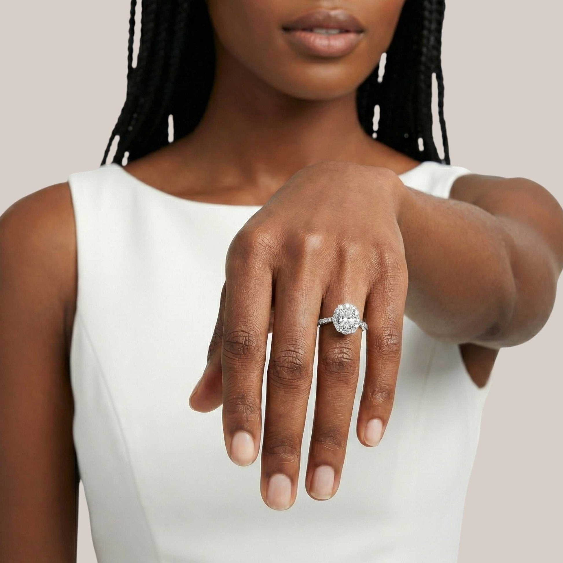 Woman wearing a diamond ring on her hand against a neutral background