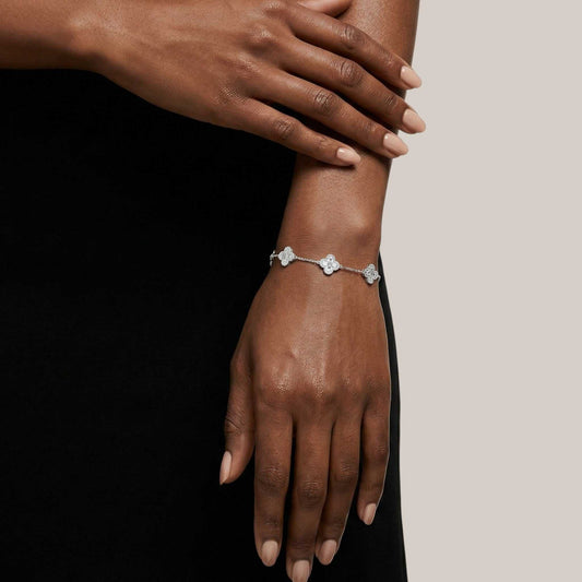 Silver bracelet on a wrist with a neutral background