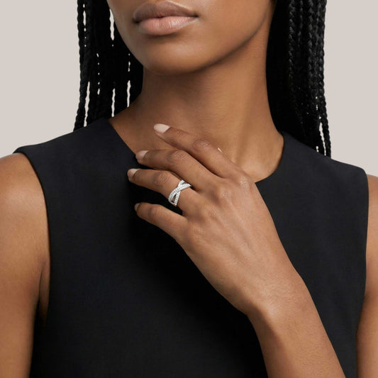 Woman wearing a black sleeveless top with a close-up of her hand and ring.
