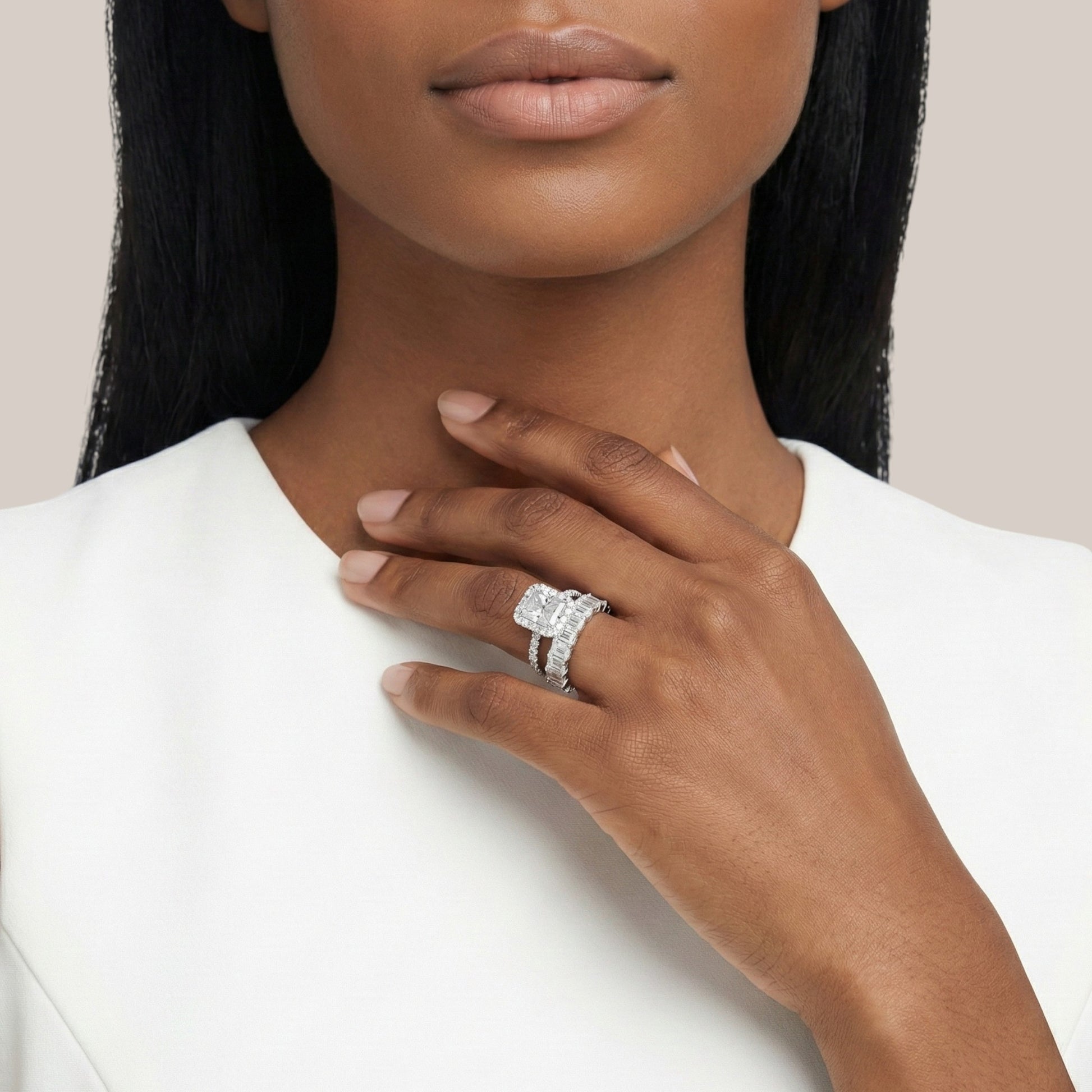 Woman wearing a diamond ring on a plain background
