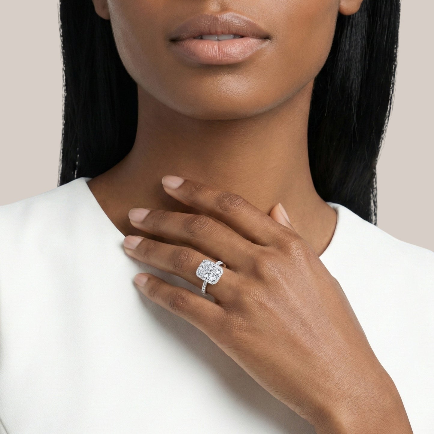 Woman wearing a diamond ring on her hand with a neutral background