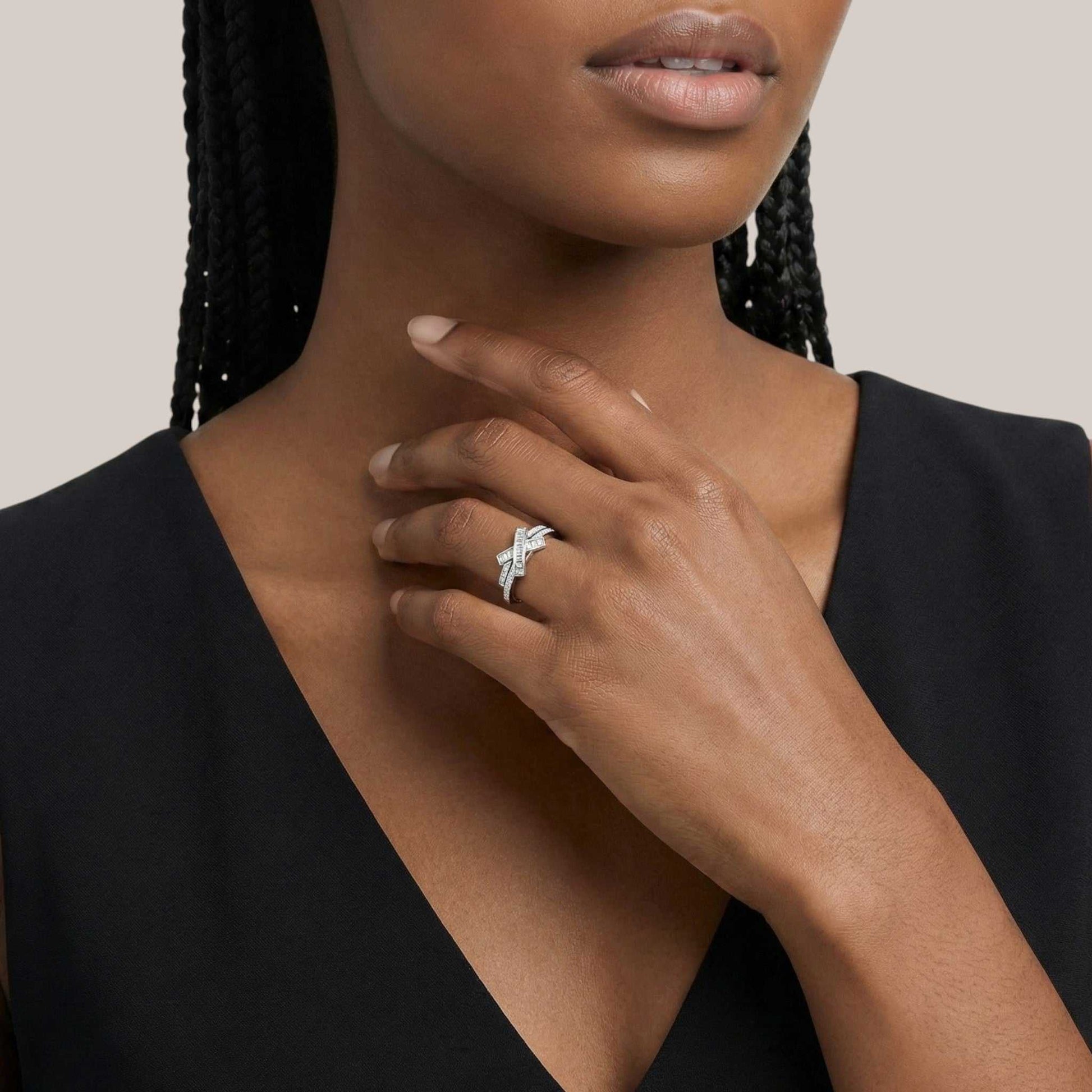 Woman wearing a silver ring on her hand with a neutral background