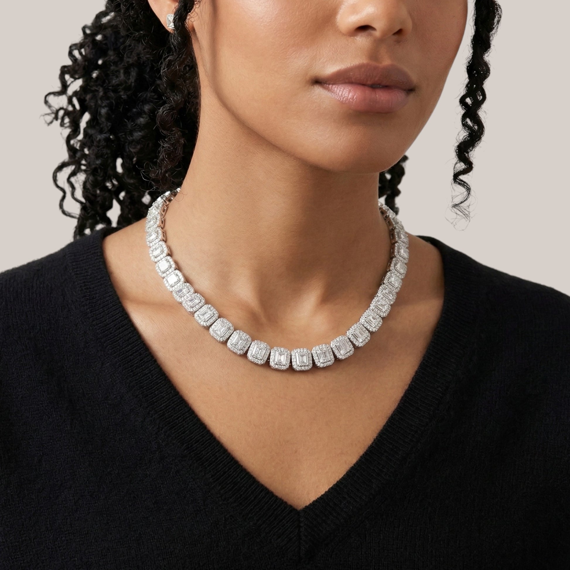 Woman wearing a diamond necklace against a neutral background