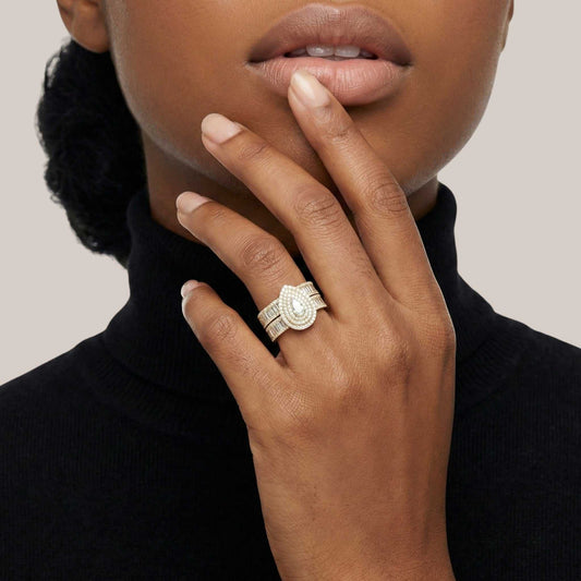 Close-up of a hand wearing a silver ring with a black turtleneck background