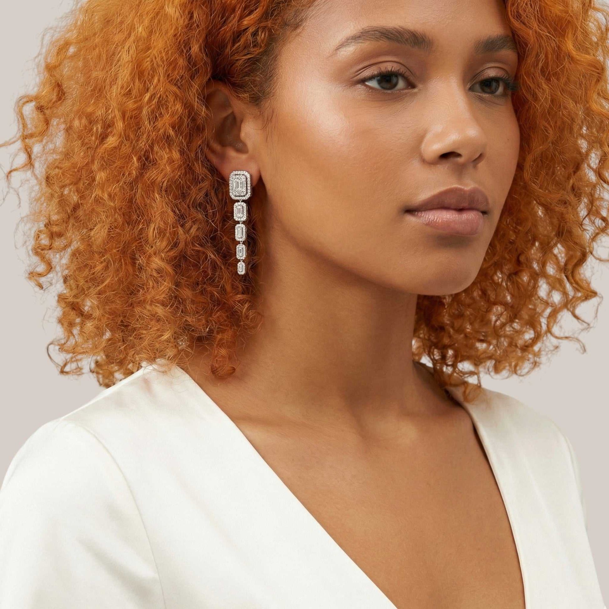 Woman wearing a white top with a plain background