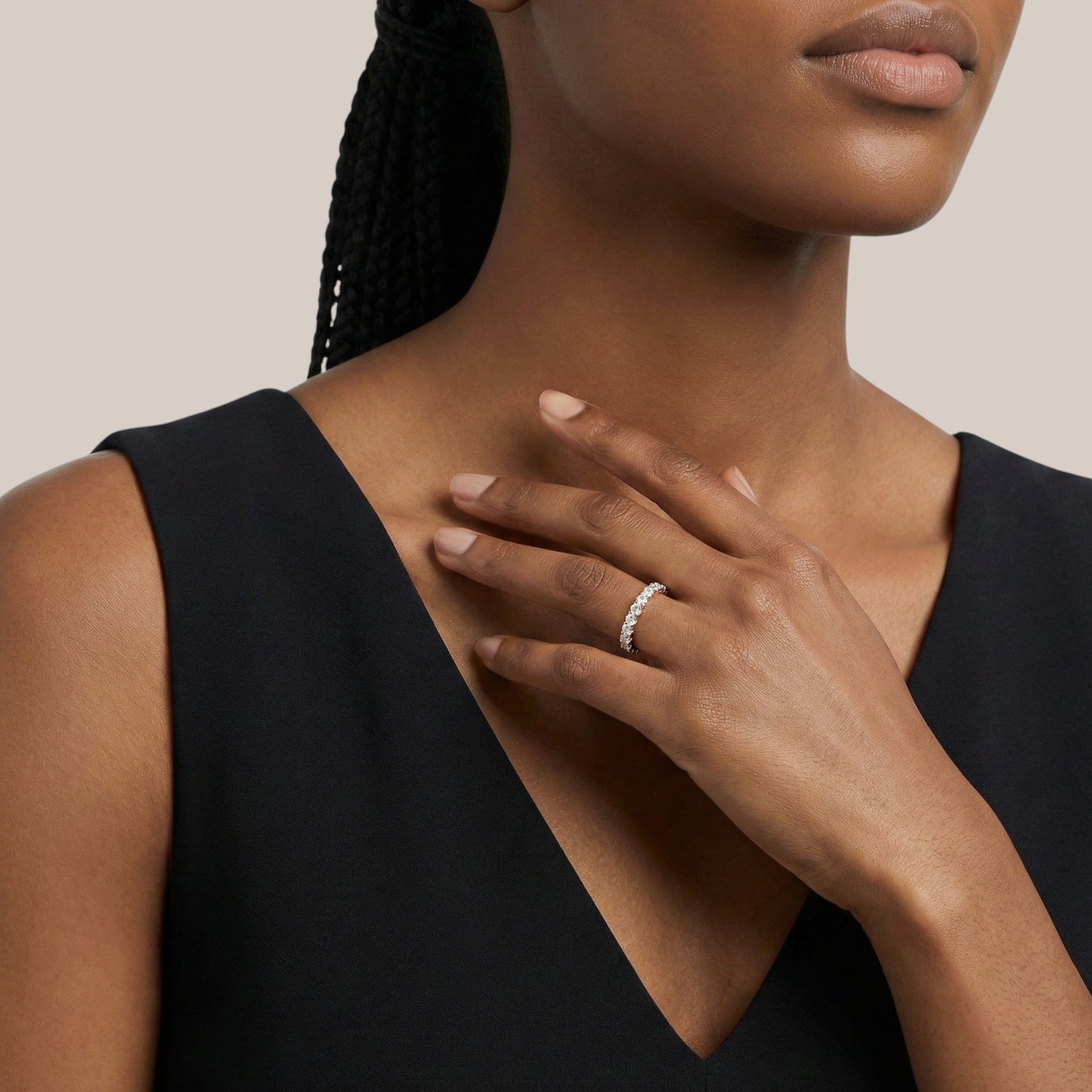 Woman wearing a black sleeveless top with a neutral background