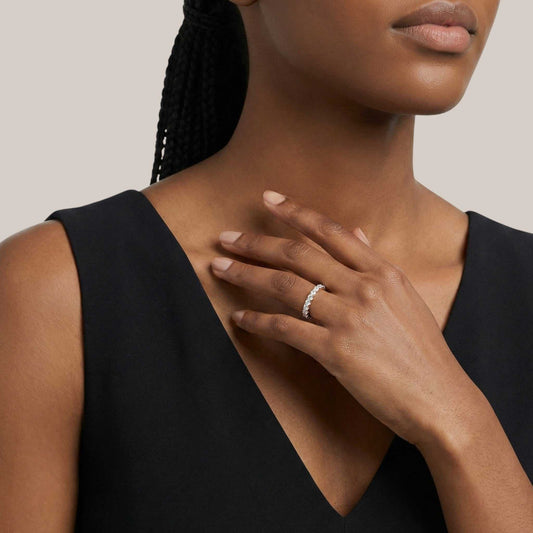 Woman wearing a black sleeveless top with a neutral background