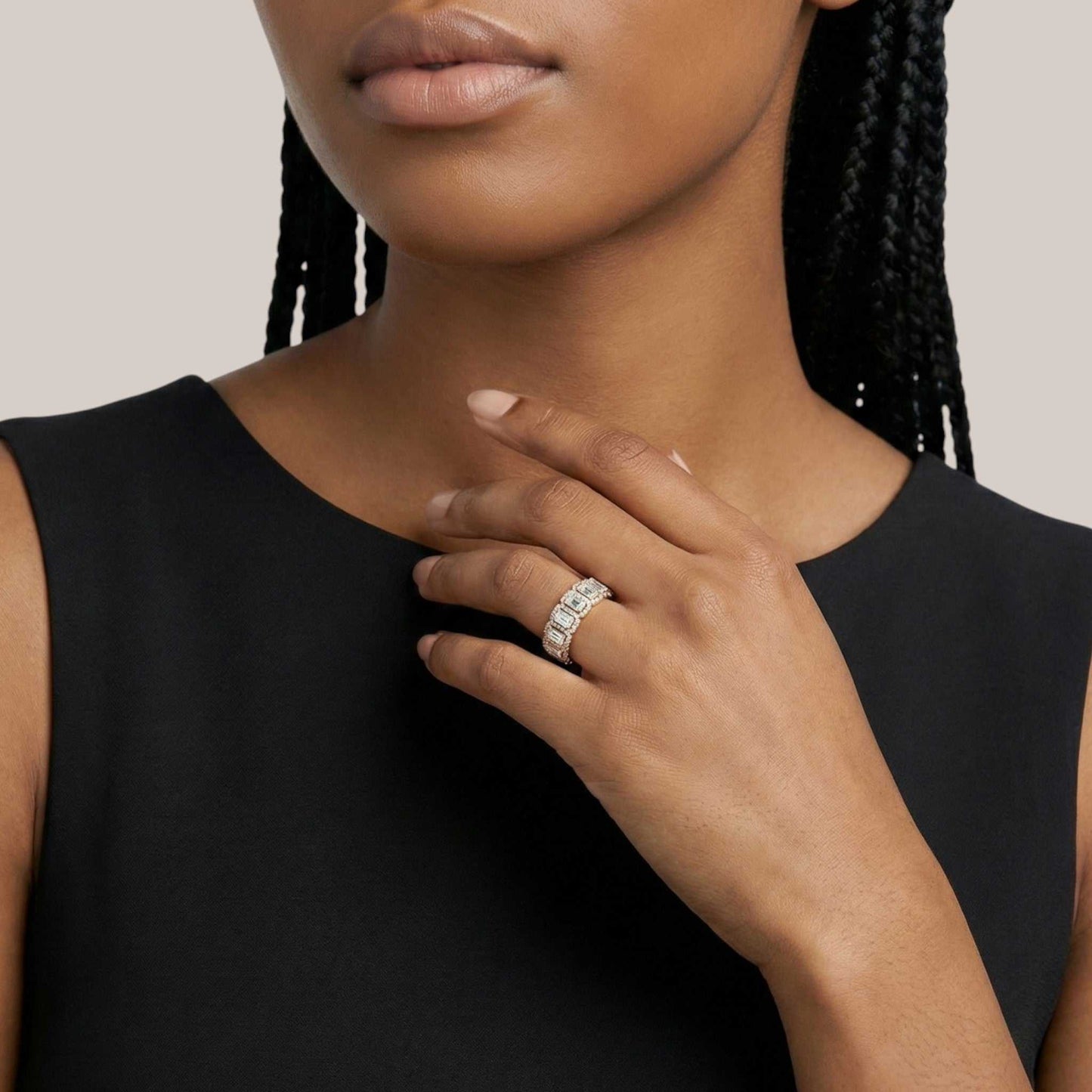 Woman wearing a black sleeveless top with a close-up of her hand and ring.