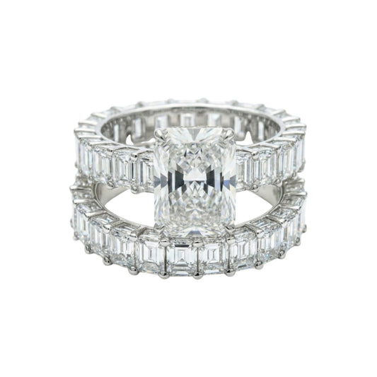 Diamond ring with emerald-cut center stone and baguette side stones on a white background