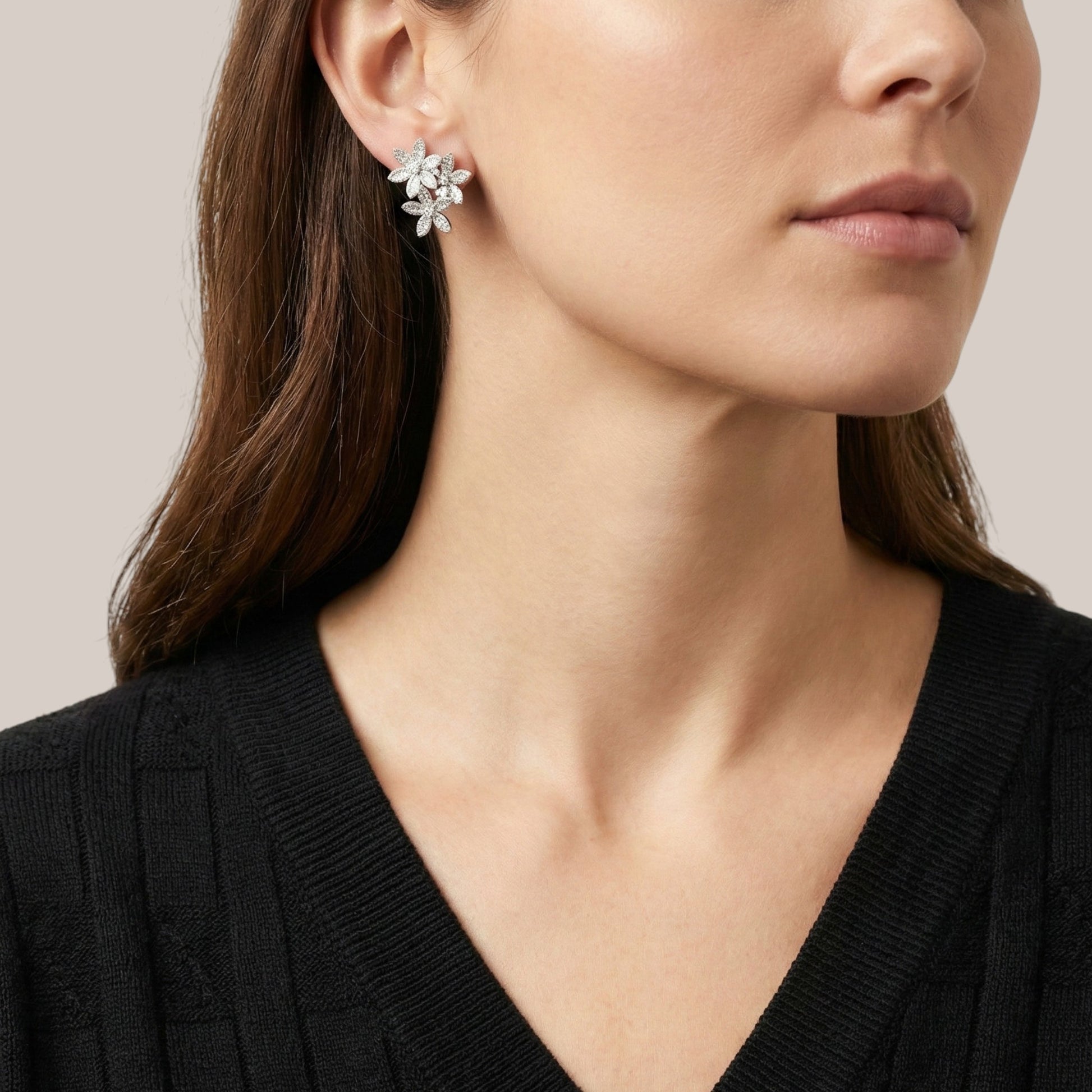 Close-up of a woman wearing a floral earring with a neutral background