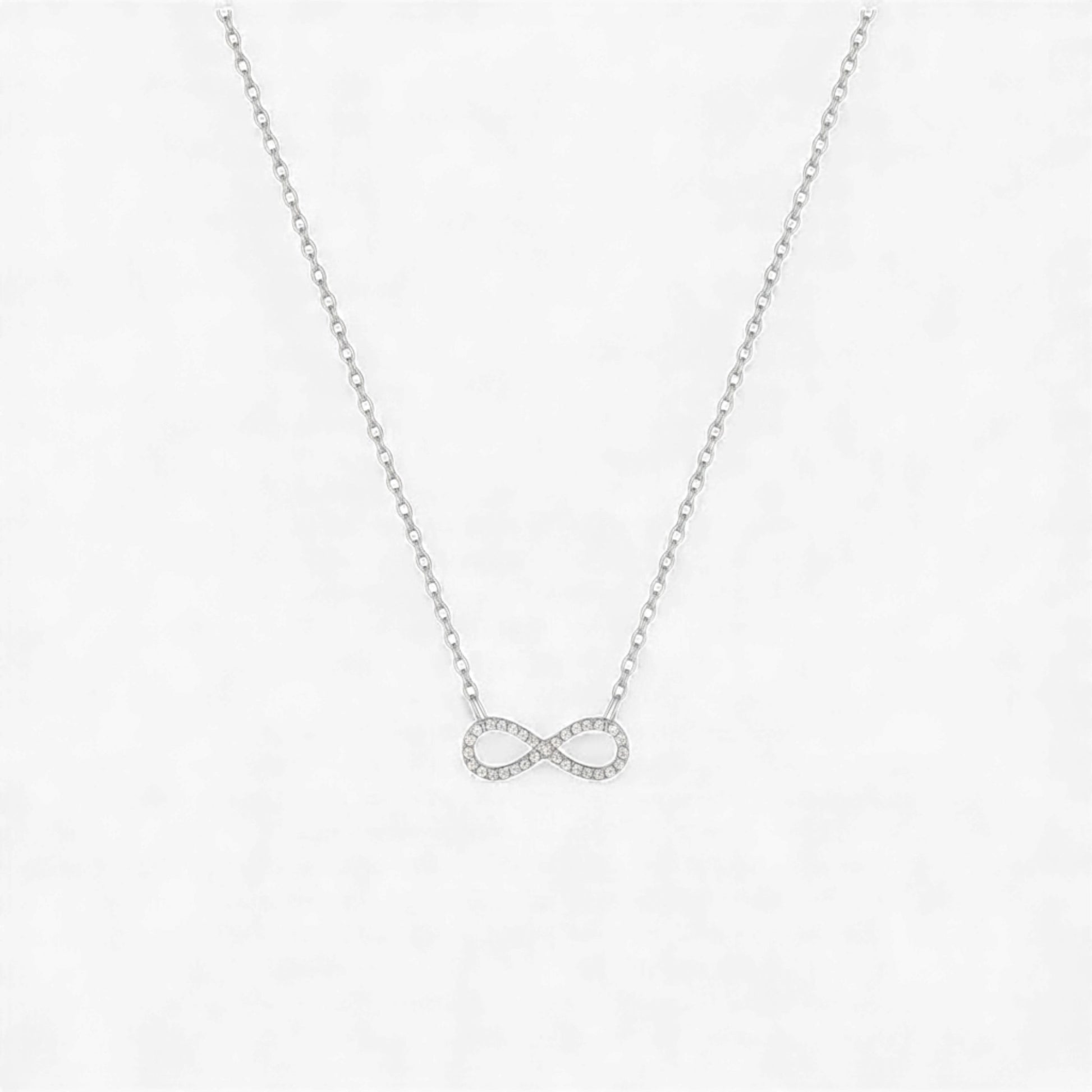 Silver infinity necklace on a light gray background