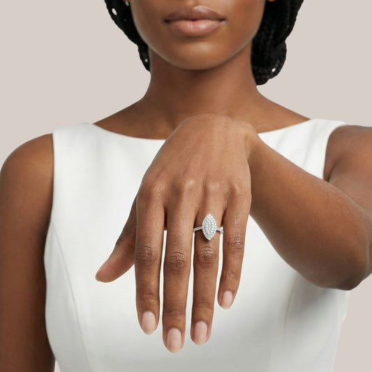 Woman wearing a diamond ring on her hand against a neutral background