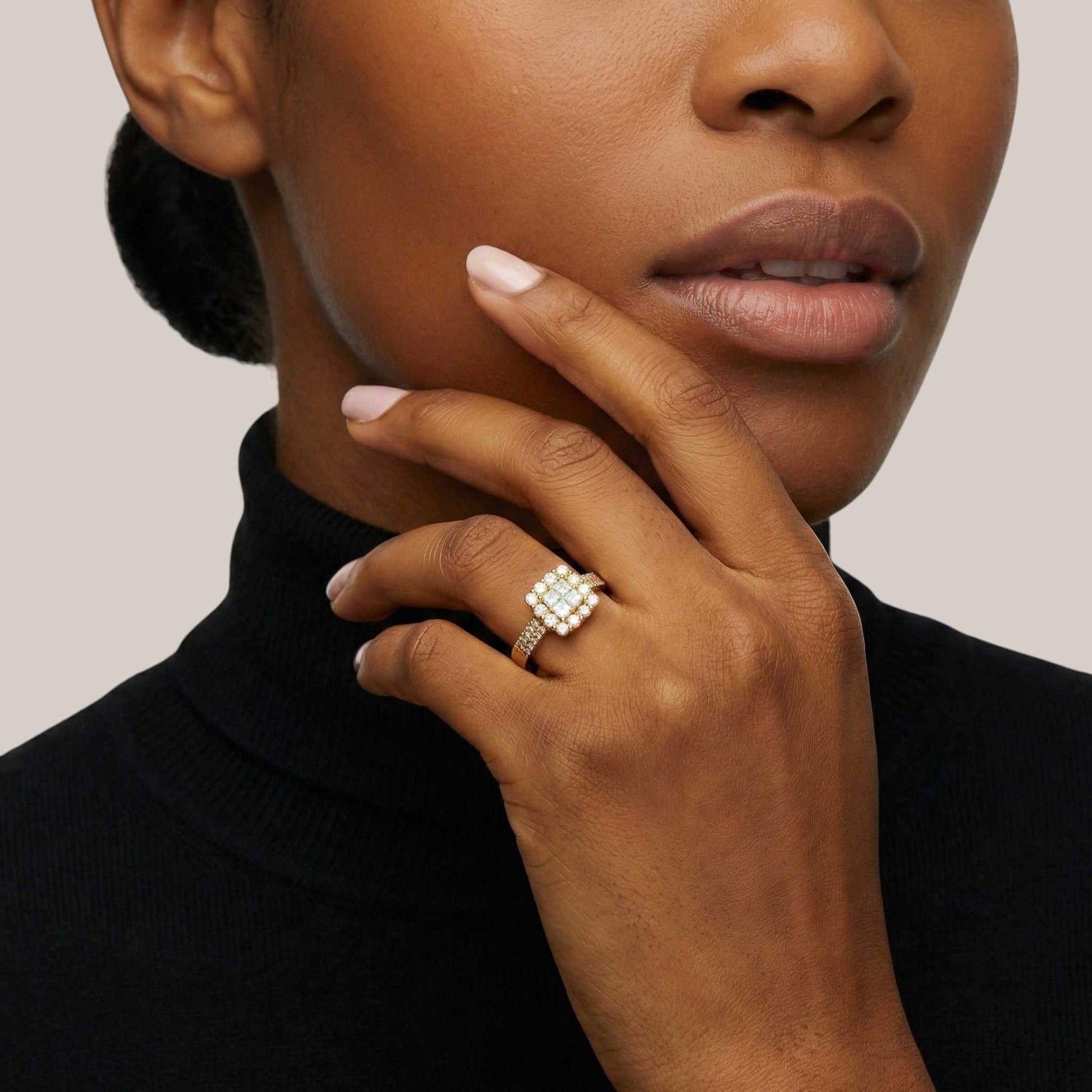 Close-up of a woman's hand wearing a diamond ring with a neutral background