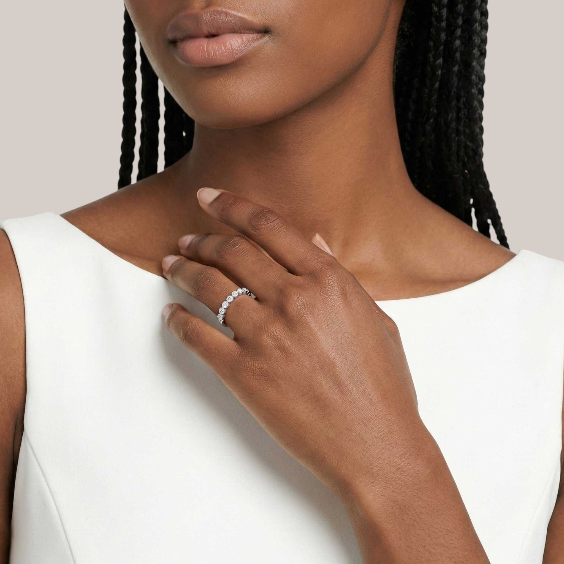 Woman wearing a silver ring on her hand with a plain background