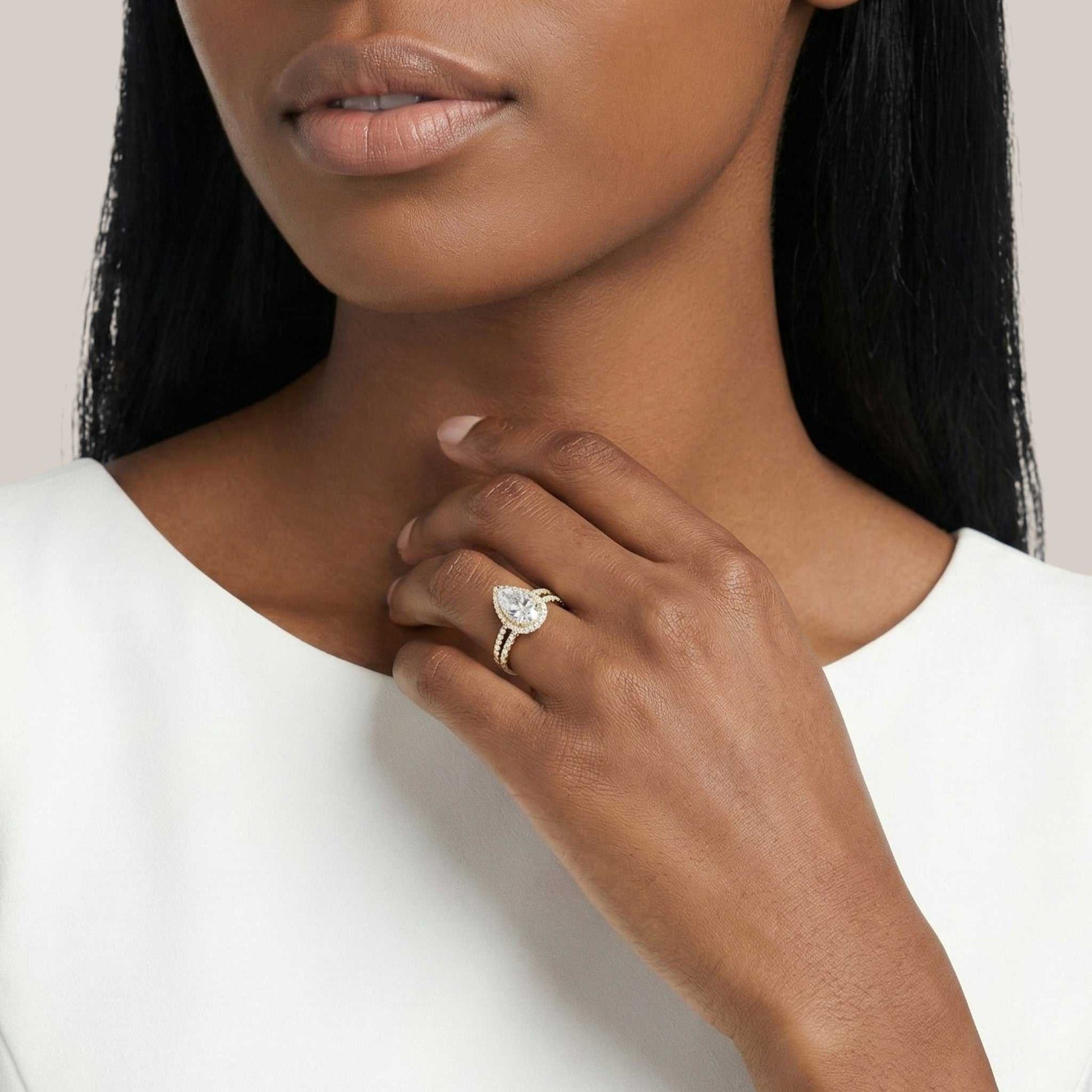 Woman wearing a diamond ring on her hand with a plain background