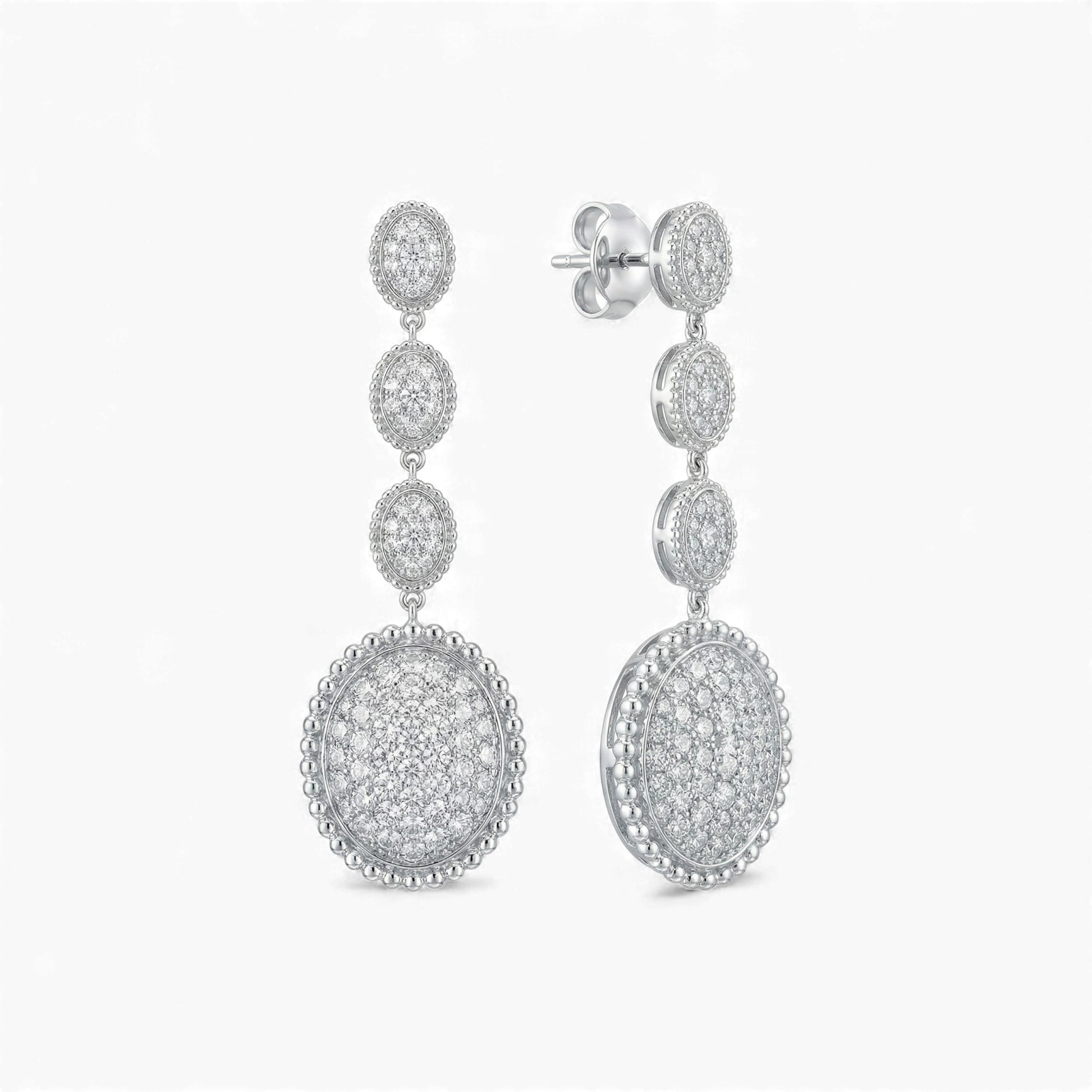 Pair of silver earrings with circular designs on a white background