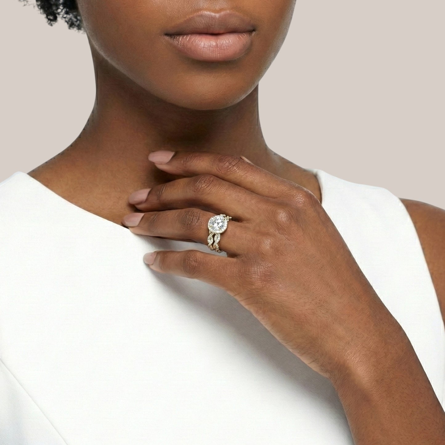 Woman wearing a diamond ring on a plain background